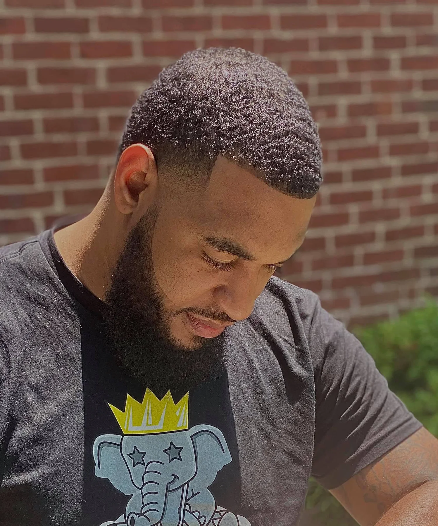 Outdoor portrait showing defined waves, a crisp lineup, temple taper, and beard edge